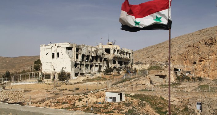 A bandeira síria no fundo das casas em ruínas na cidade síria de Maaloula, 55 km de Damasco, que foi duas vezes capturado e saqueado por militantes Jabhat al-Nusra.