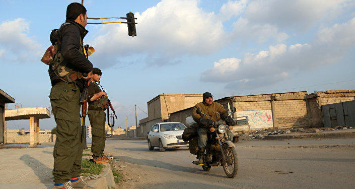 Os membros das forças de segurança curdas internos (conhecidos como Asayish) verificar os veículos em 16 de dezembro de 2015 na cidade síria de Qamishli nordeste