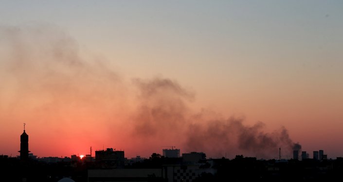 Uma coluna de fumaça negros no céu em meio a confrontos entre facções rivais líbios em Benghazi.