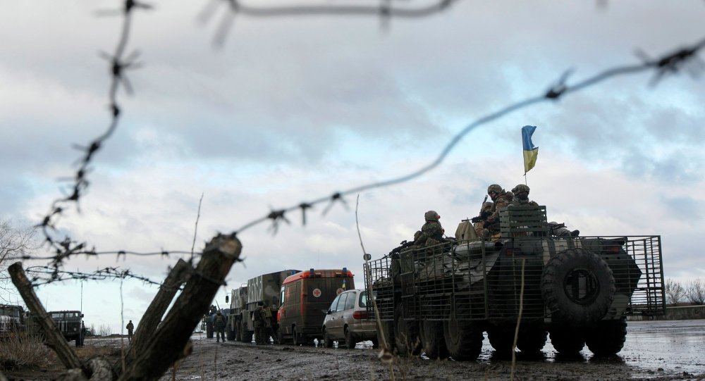 Um comboio militar ucraniano é retratado através de uma cerca de arame farpado em uma base militar na cidade de Kramatorsk, leste da Ucrânia